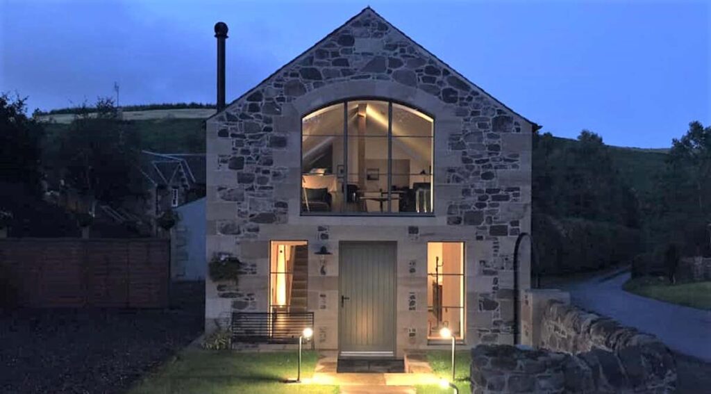 Cat lighting show house. A photo of a stone house exterior illuminated at night