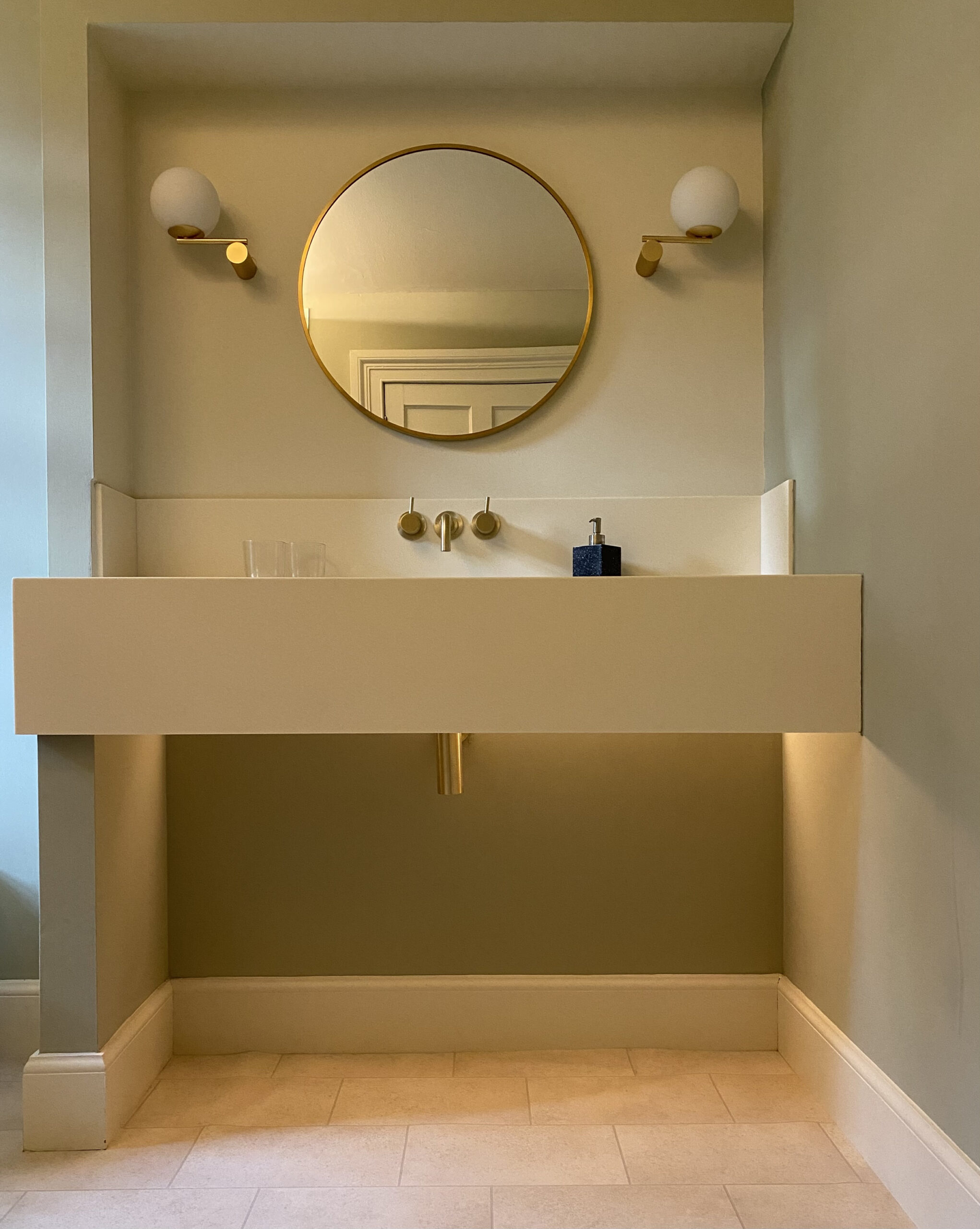 5 tips for lighting a bathroom. A photo of a vanity basin with round mirror in a modern domestic bathroom